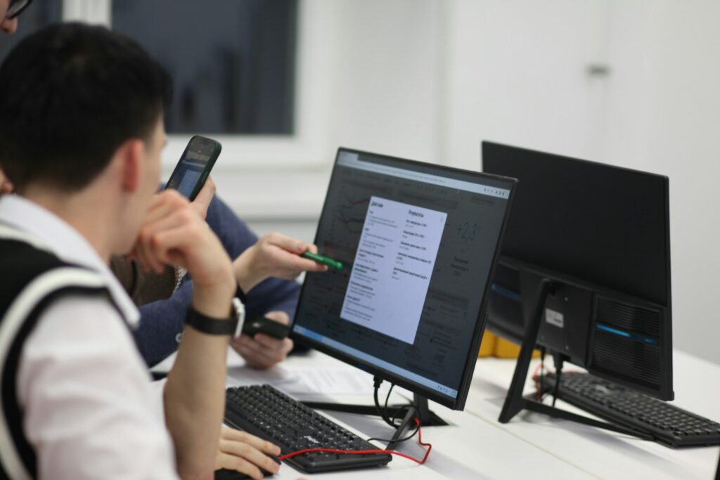 A group of people sitting at a table with computers